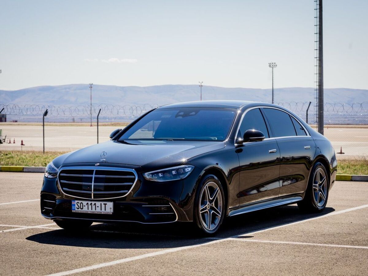 The SOIT Mercedes-Benz S-Class in an open car park, hills on the horizon.