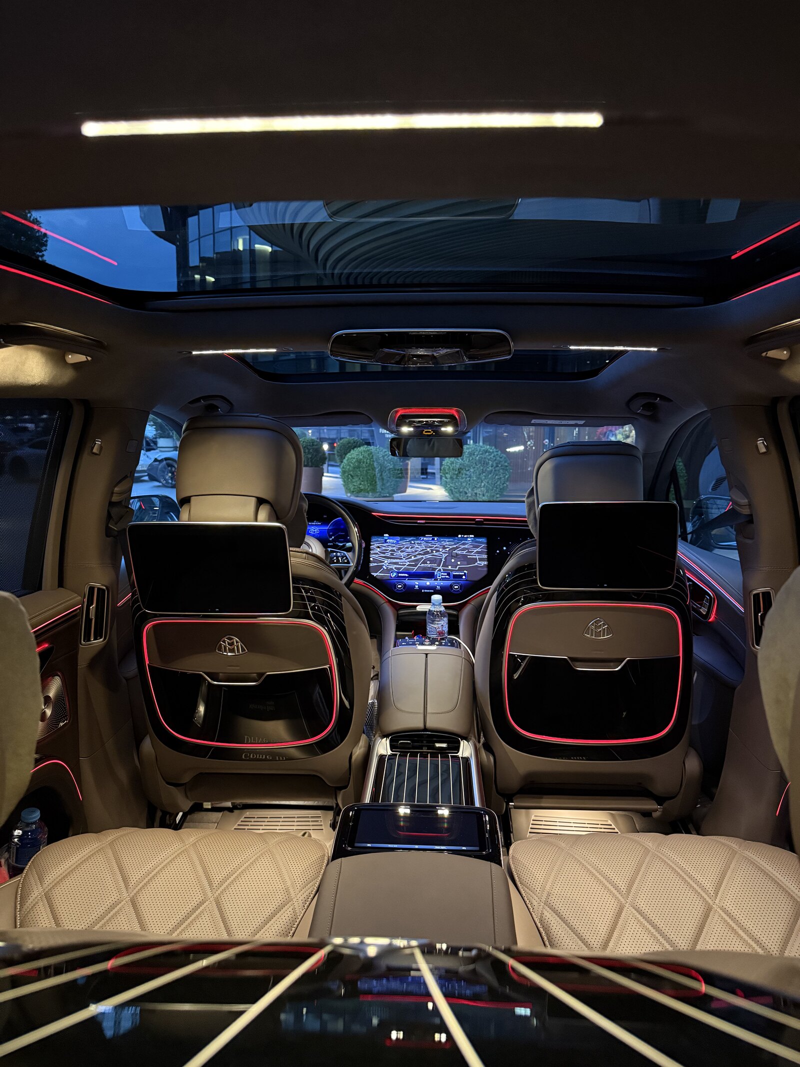 Maybach EQS rear seats head-on — twin seatback screens and the panoramic glass roof