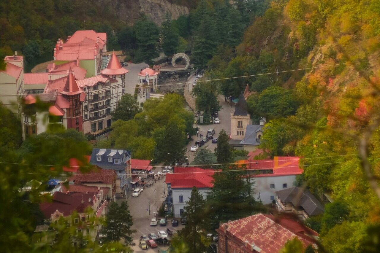A view of Borjomi from a hill: the town spreads through a green river gorge with forested mountains rising on either side.