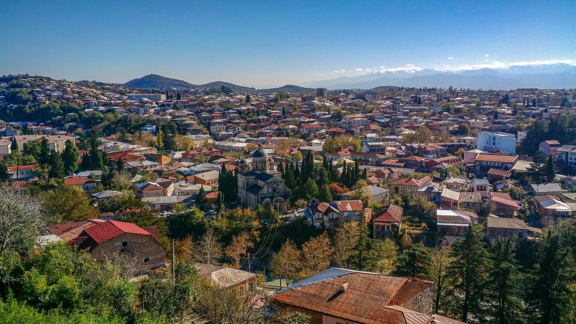 Aerial view of Kutaisi from above the Bagrati Cathedral hill: the city laid out among trees in the Rioni river valley.
