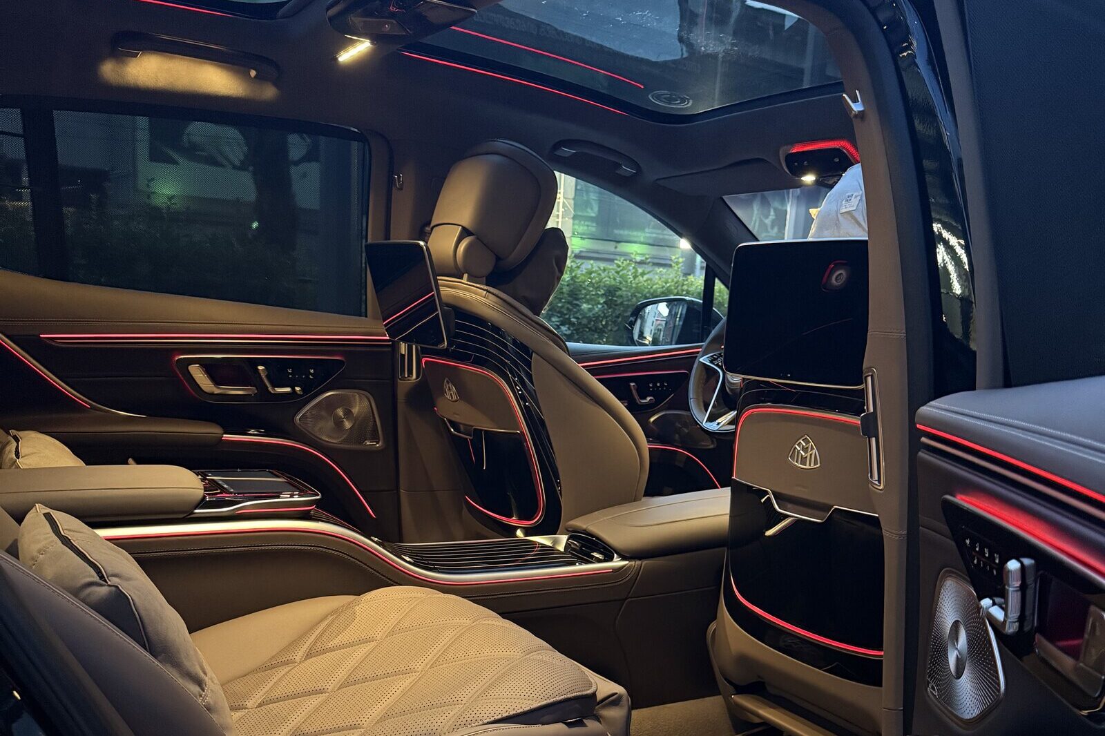 The rear cabin of a Mercedes-Maybach EQS from the right door: quilted seats, the fixed centre console and the front cabin beyond.