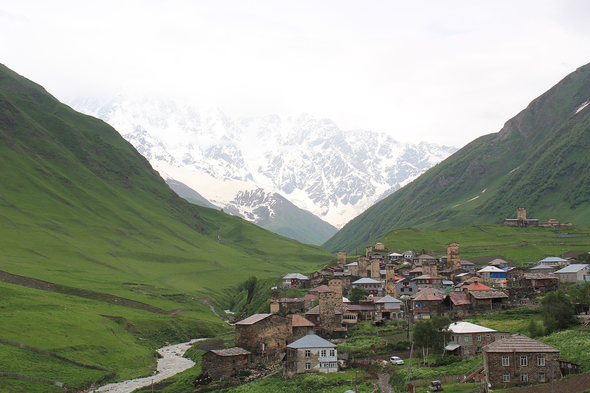 The medieval stone towers of Ushguli with Mt Shkhara's snow-capped face rising at the head of the Enguri valley.