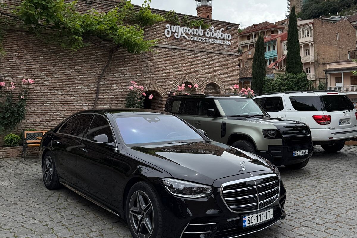 A black Mercedes S-Class parked at the entrance of Gulo's Thermal Spa in the Abanotubani sulfur-bath district of Old Tbilisi.