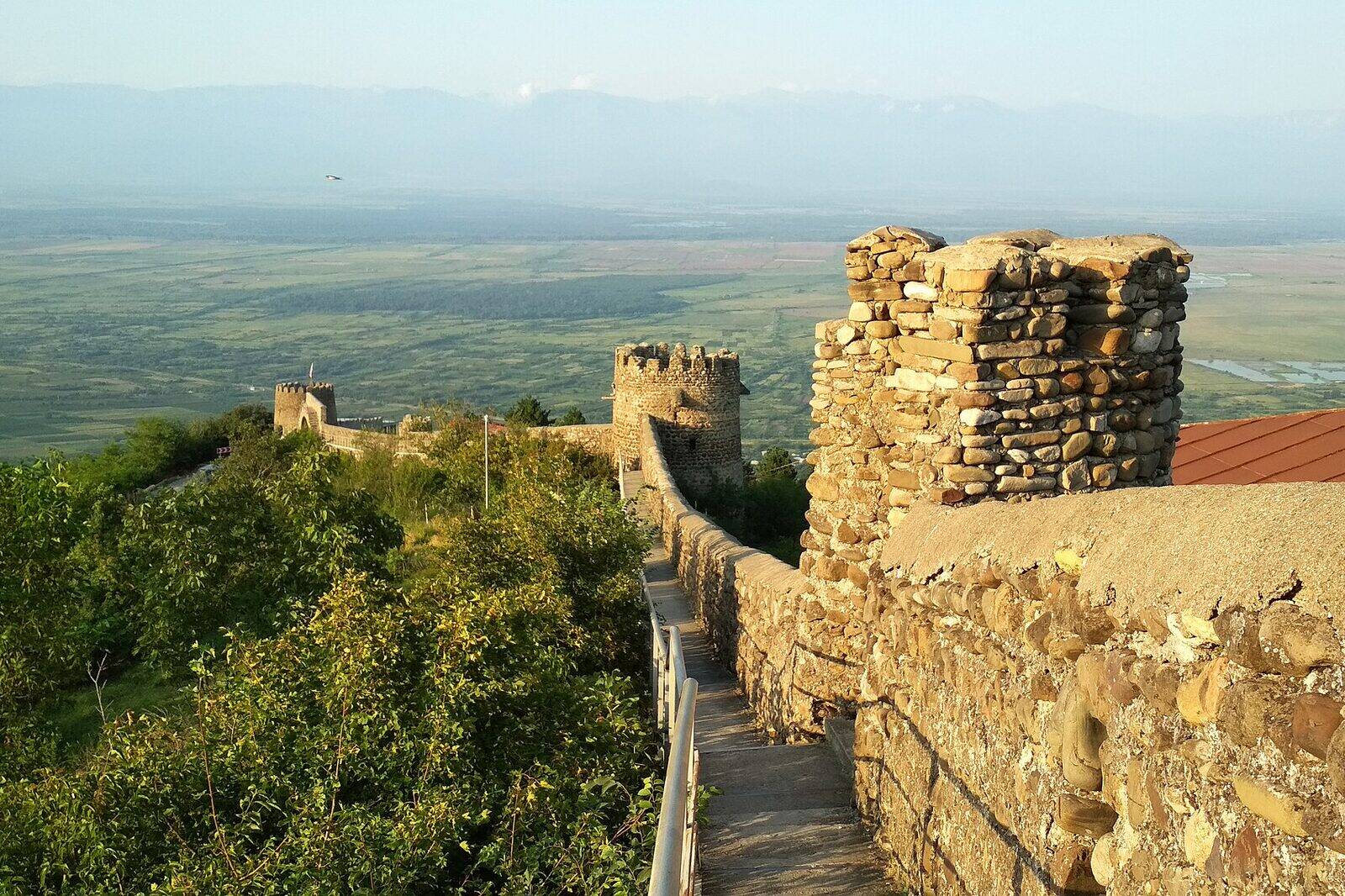 The stone walkway along Sighnaghi's town wall, its towers in a line and the flat Alazani valley stretching out below.